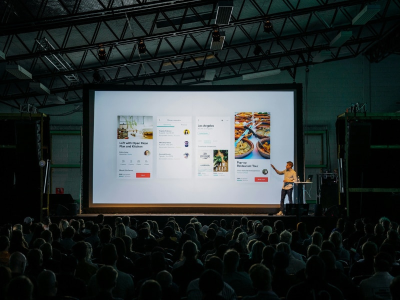 Speaker presenting a new product design to an audience at a launch event.