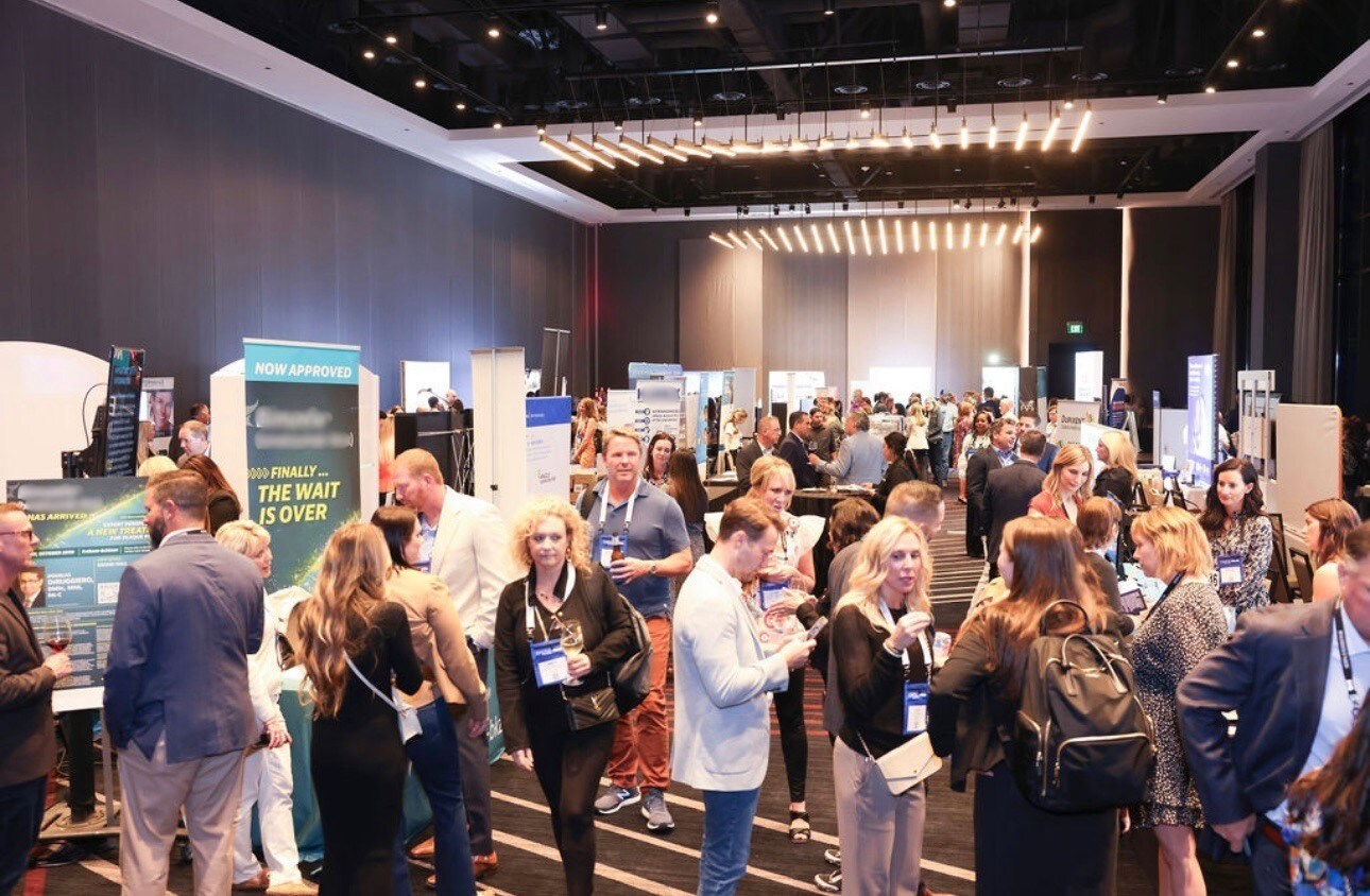 Attendees exploring the exhibition and sponsor floor at an event.