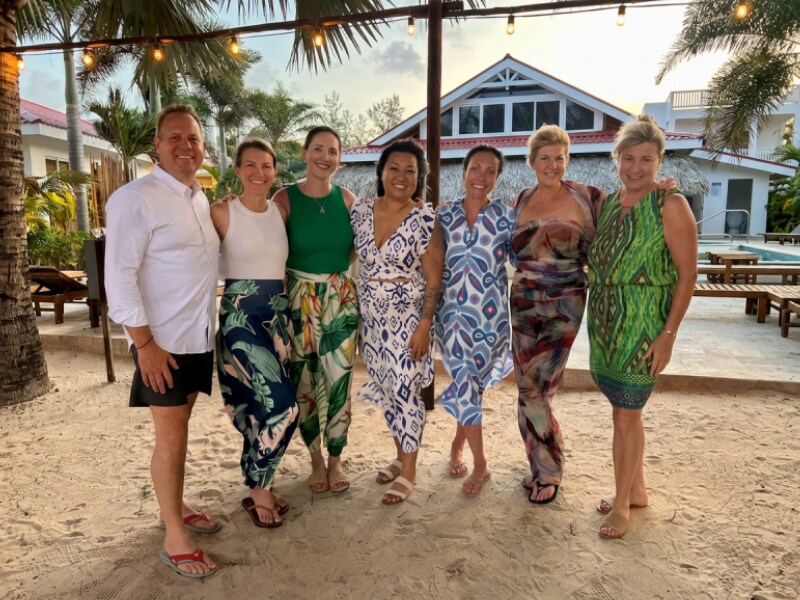 Group gathered outdoors at a tropical resort.