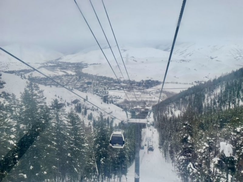 A cable car going down a snowy mountain
