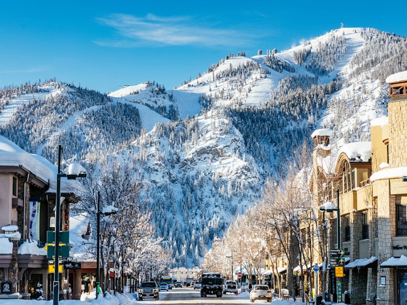 A snowy street with buildings and trees