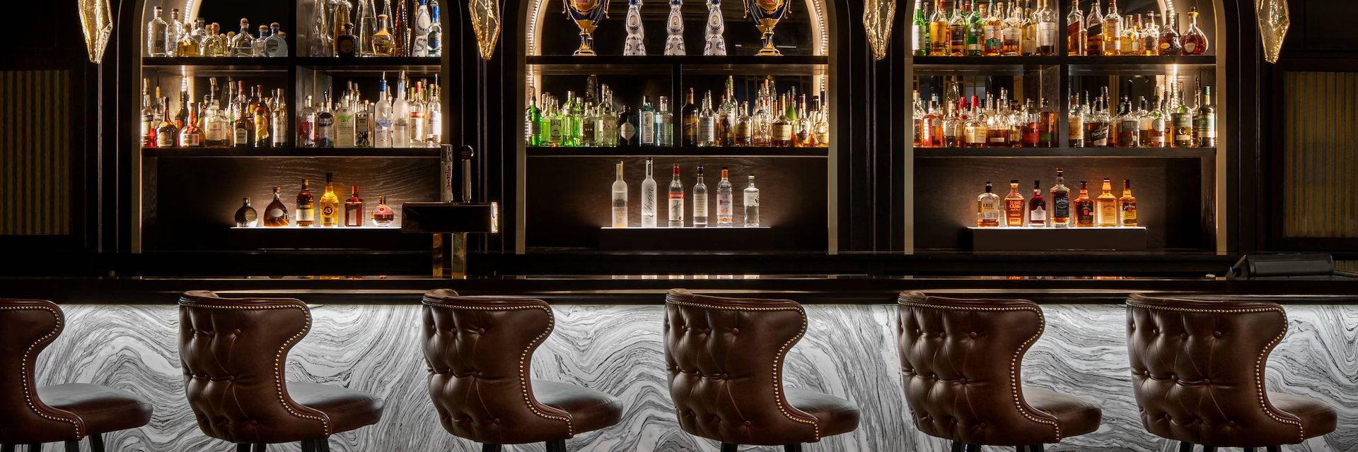 A bar with a large bar counter and a few stools