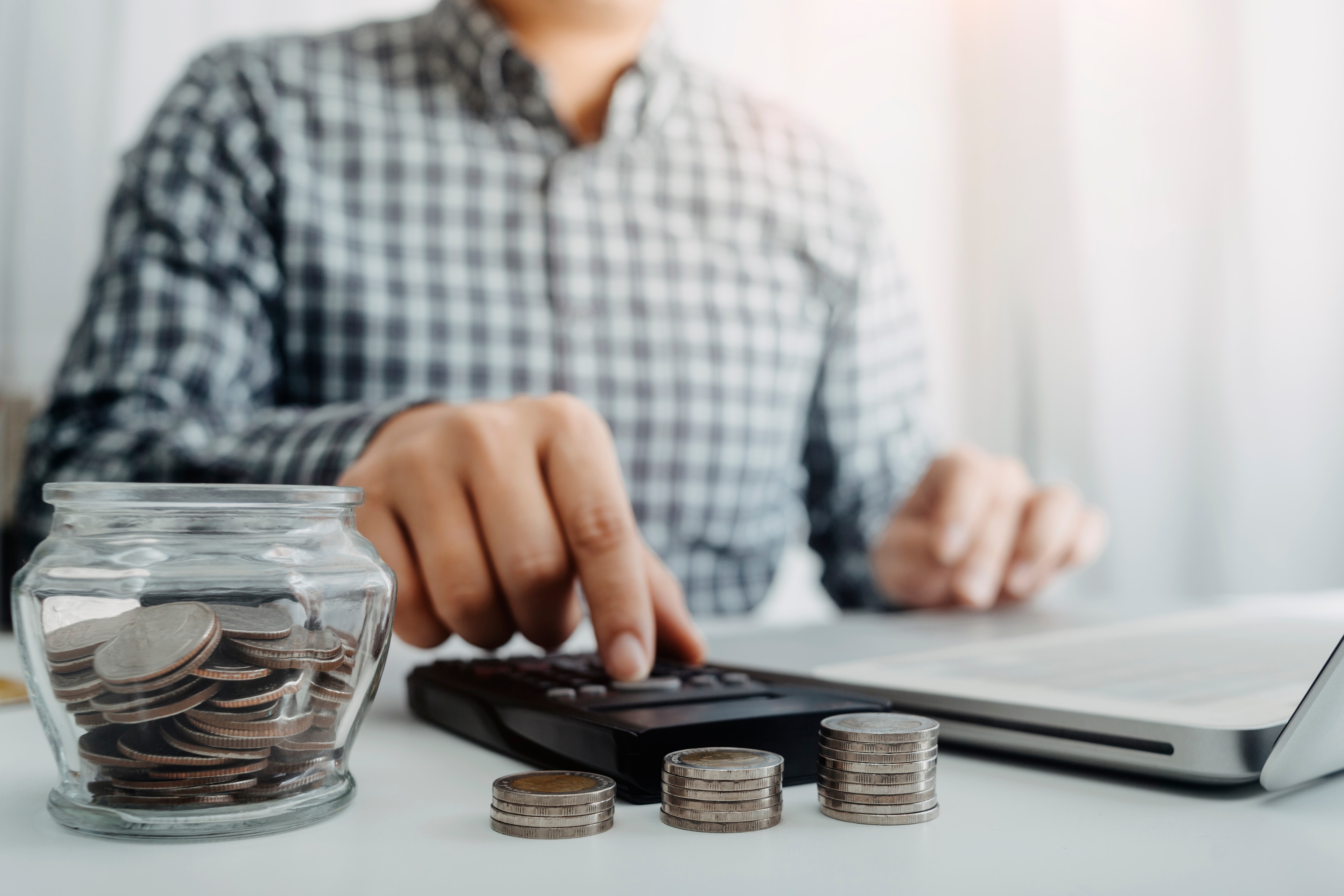 Person calculating savings with debt consolidation loan.