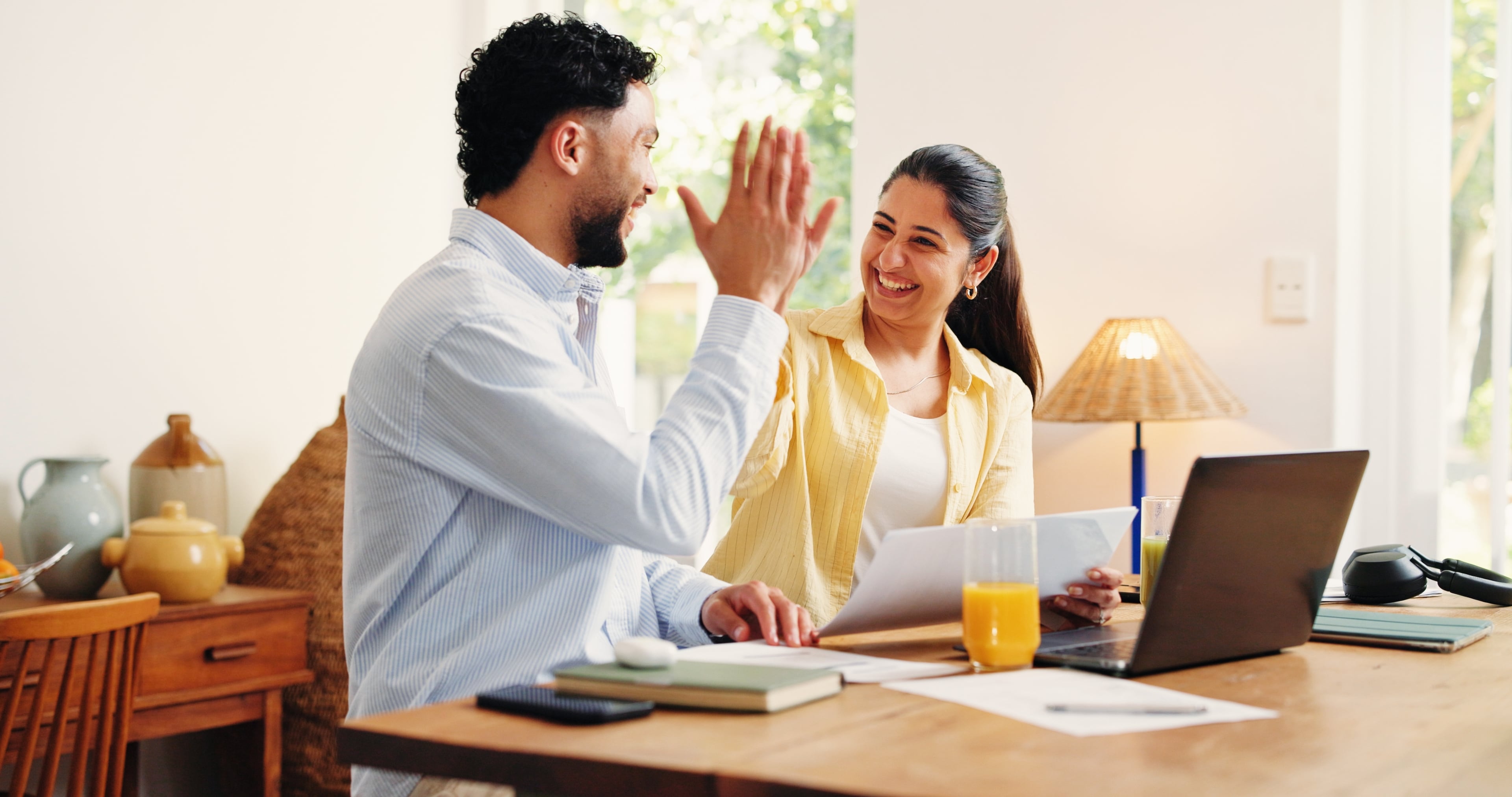 Couple high fives while submitting their 2026 taxes.