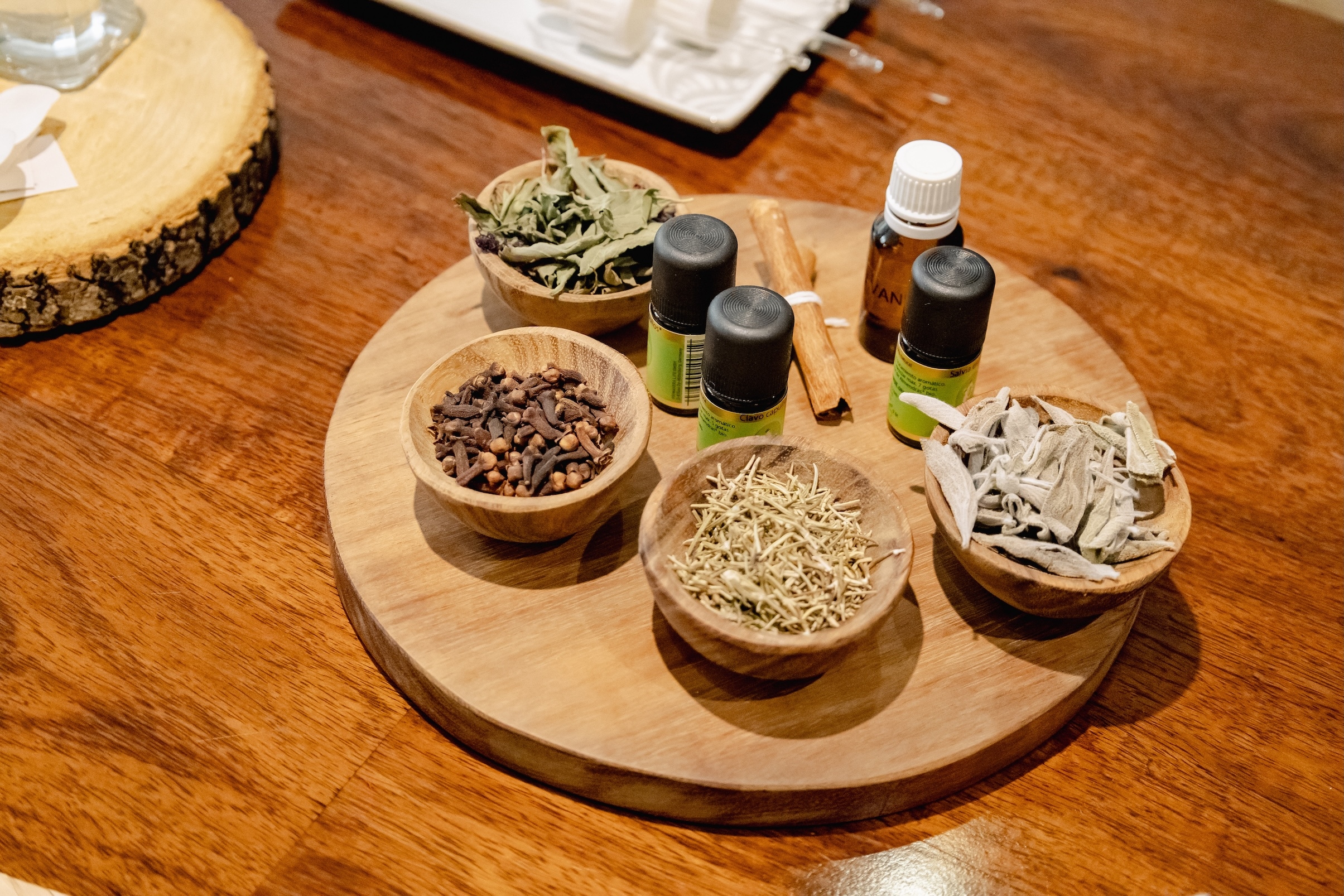 A group of bowls of herbs and spices on a wood surface