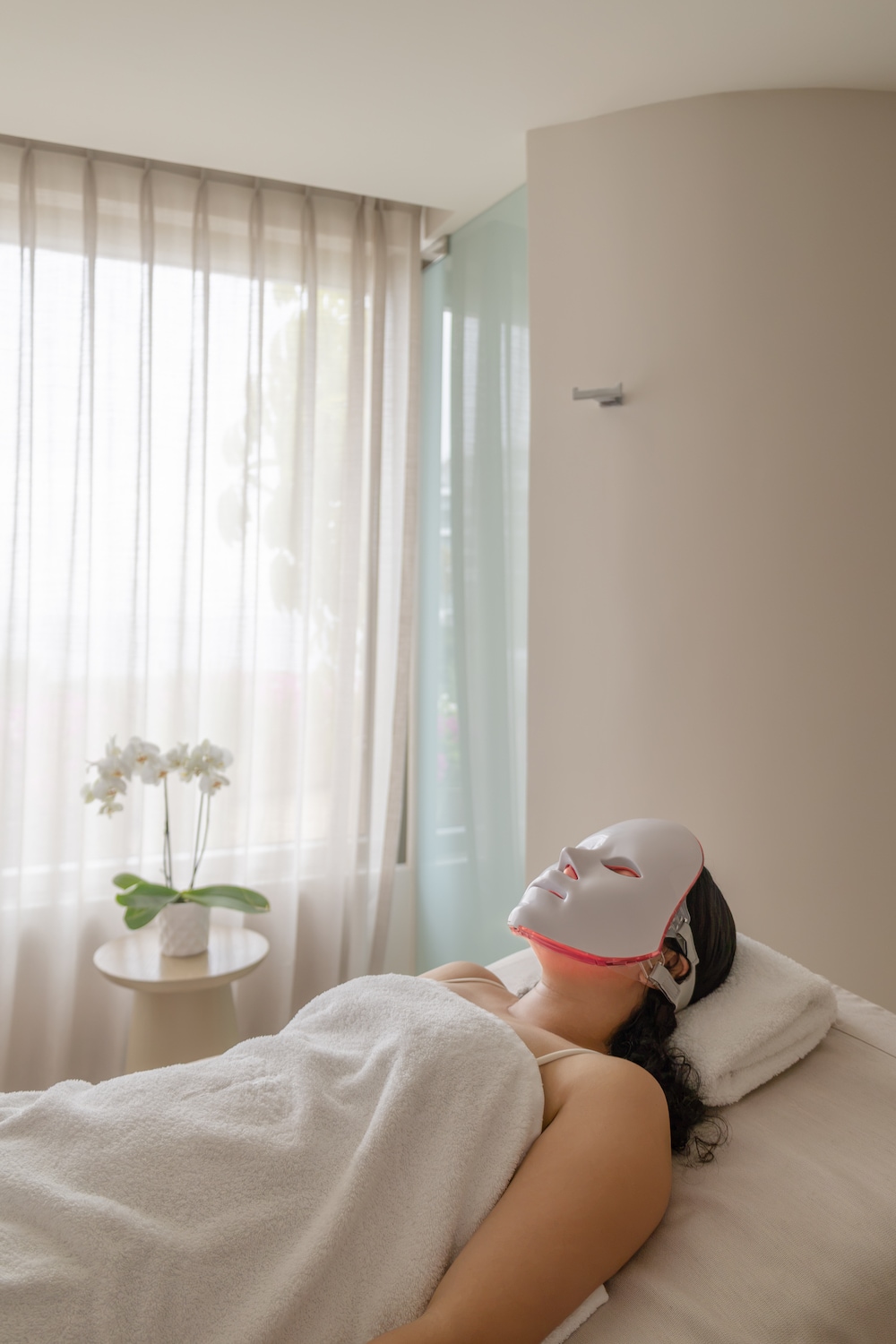 A woman lying on a bed with a mask on her face