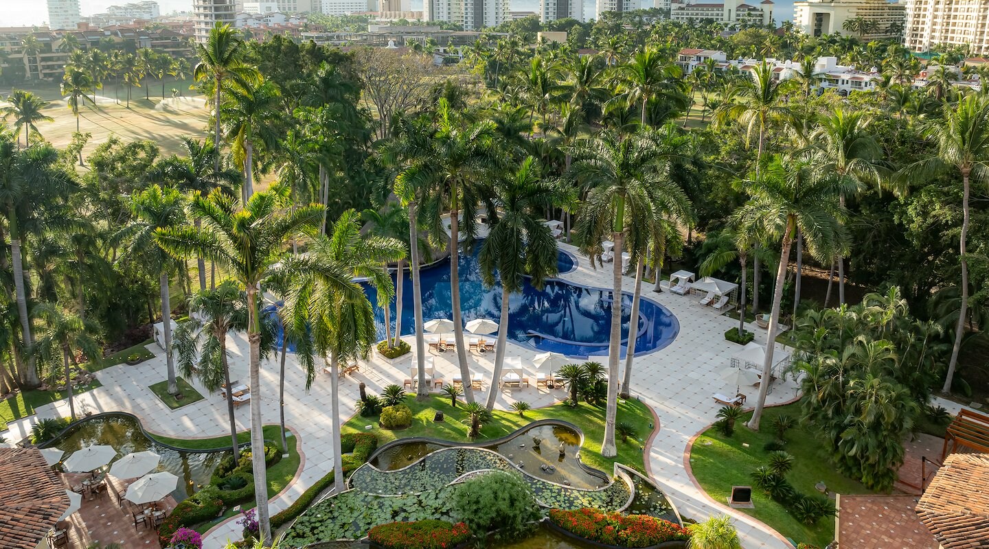 A view of a pool surrounded by palm trees and buildings, Casa Velas, Puerto Vallarta, Mexico