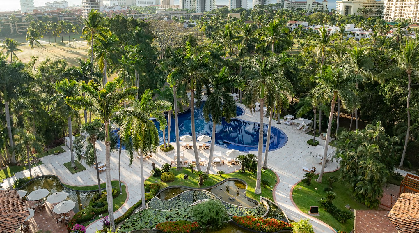 A view of a pool surrounded by palm trees and buildings, Casa Velas, Puerto Vallarta, Mexico