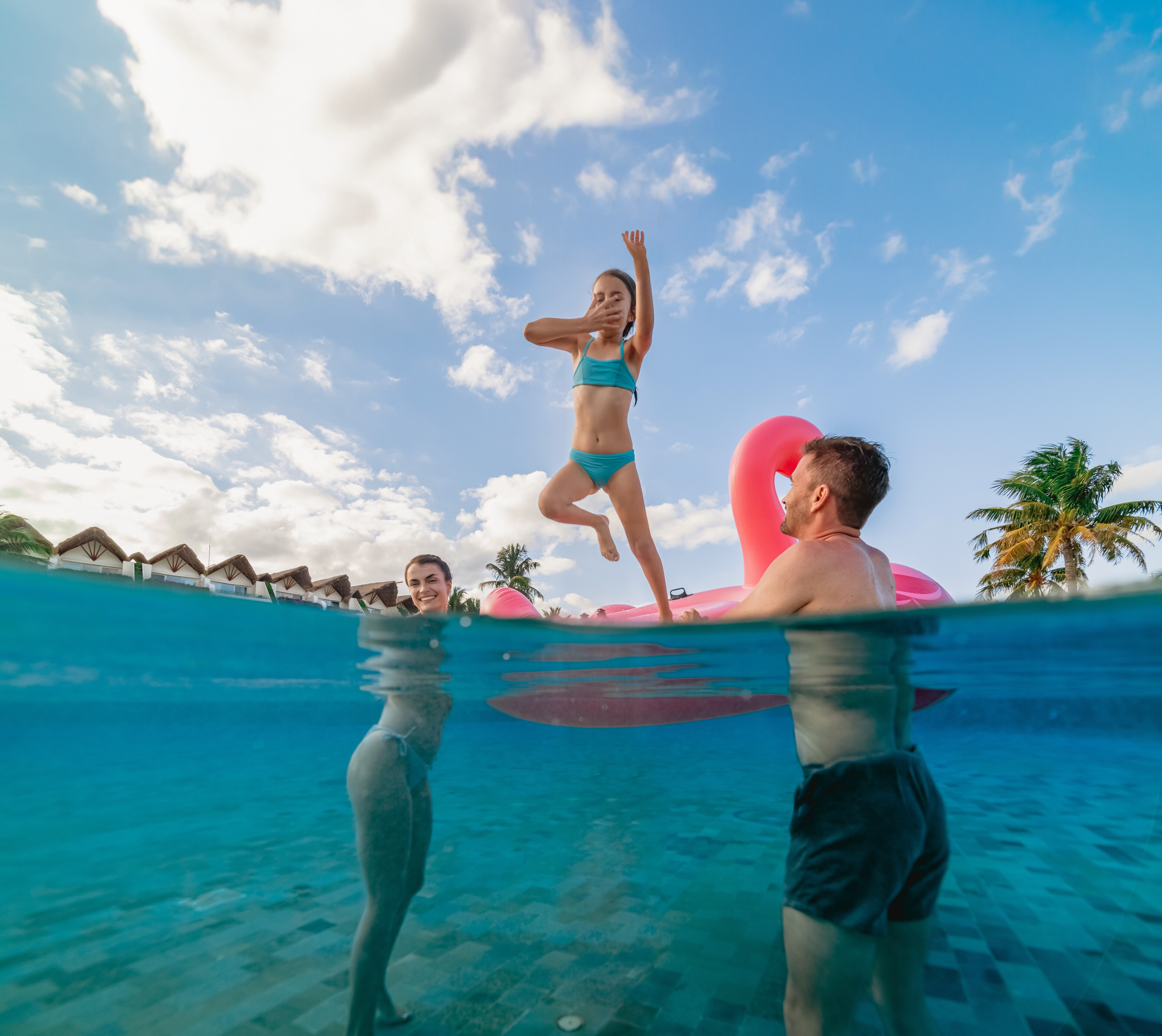 Familia nadando en el mar con un salvavidas en forma de flamingo rosa, Grand Velas Riviera Maya, Playa del Carmen, México