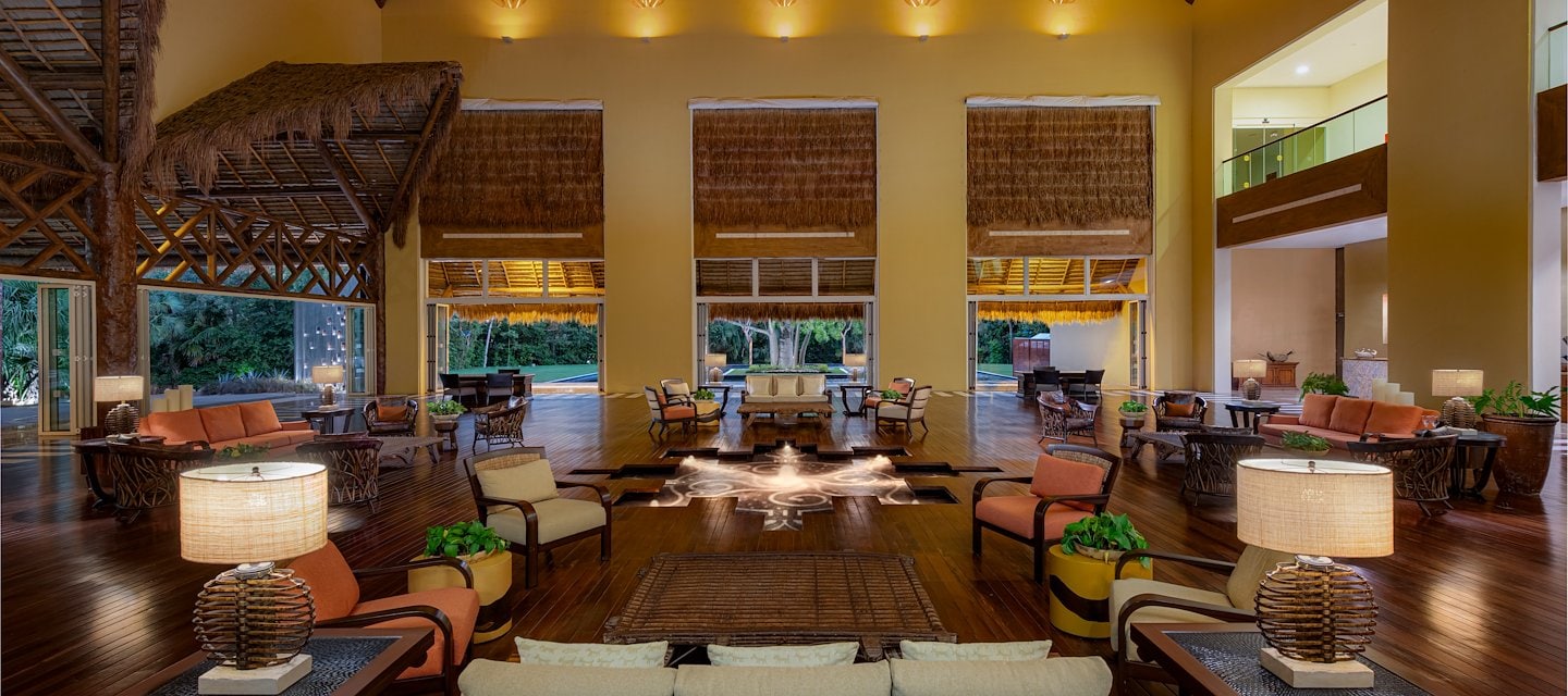 A large lobby with a large fireplace and lots of furniture, Grand Velas Riviera Maya, Playa del Carmen, Mexico