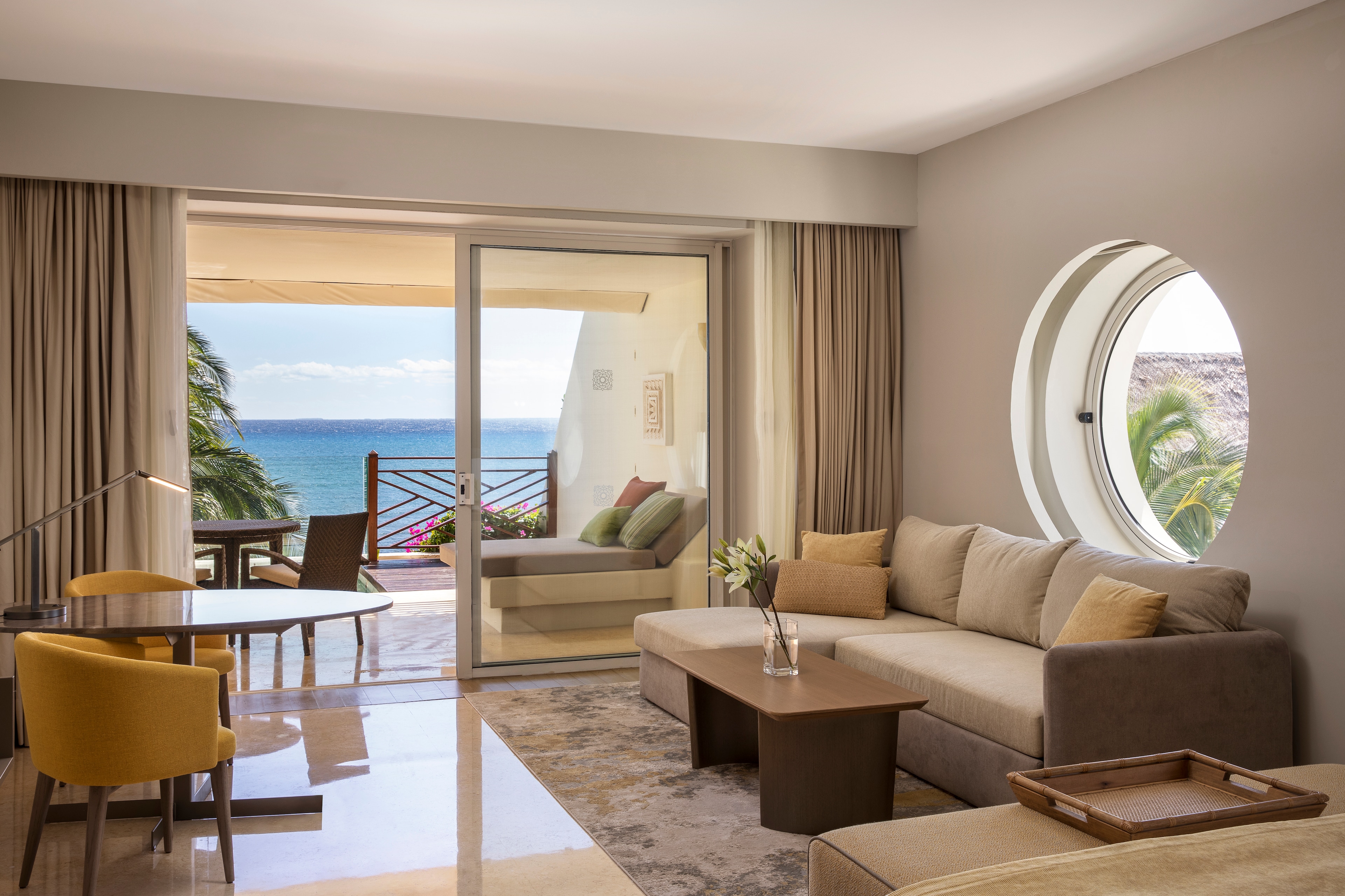 A living room with a round window overlooking the ocean, Grand Velas Riviera Maya, Playa del Carmen, Mexico