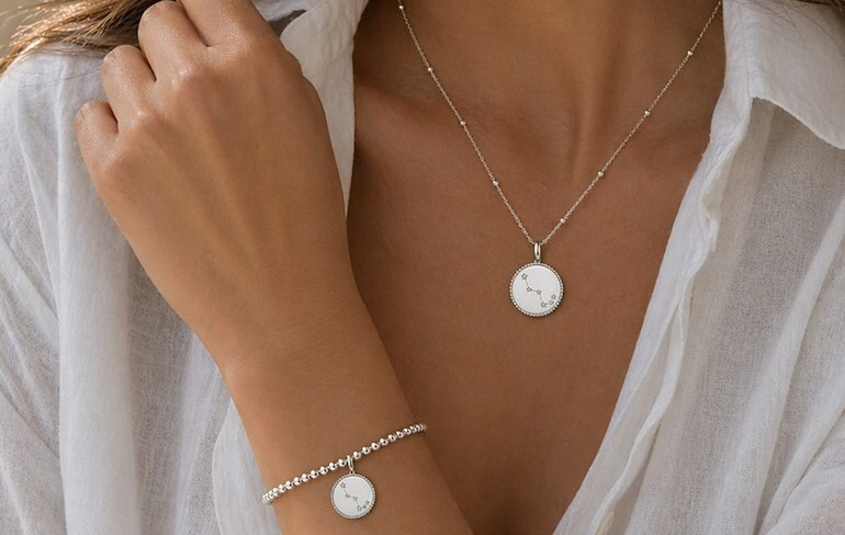 a woman wearing a necklace and a silver bracelet