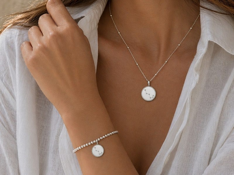 A woman wearing a white shirt and a silver necklace
