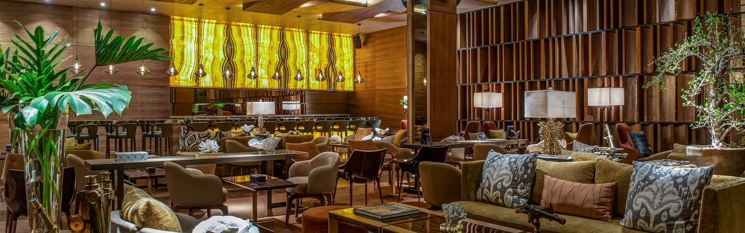 The lobby of a hotel with a large bar and couches, Grand Velas Los Cabos, San Lucas, Mexico