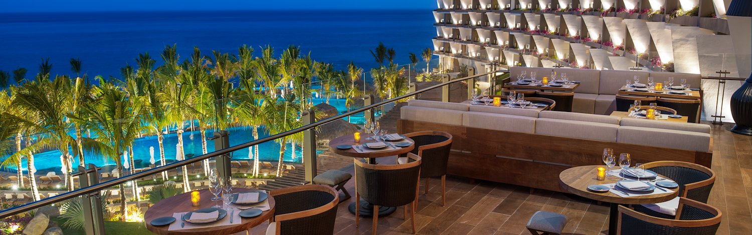 A restaurant overlooking the ocean with tables and chairs, Grand Velas Los Cabos, San Lucas, Mexico