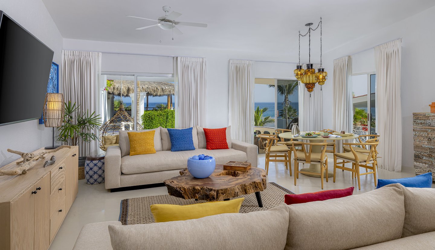 Bright, ocean-view penthouse living and dining area with colorful pillows at Mar del Cabo, San Lucas