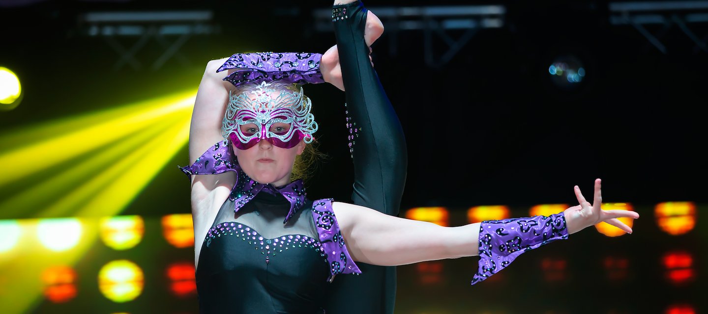 Mujer con vestuario morado presentándose en un escenario