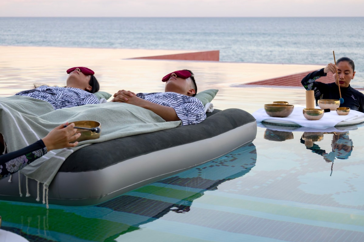 A couple of people lying on a mattress in a pool