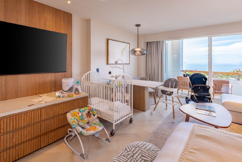 A room with a crib and a television