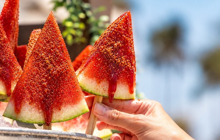 A hand holding a watermelon popsicle