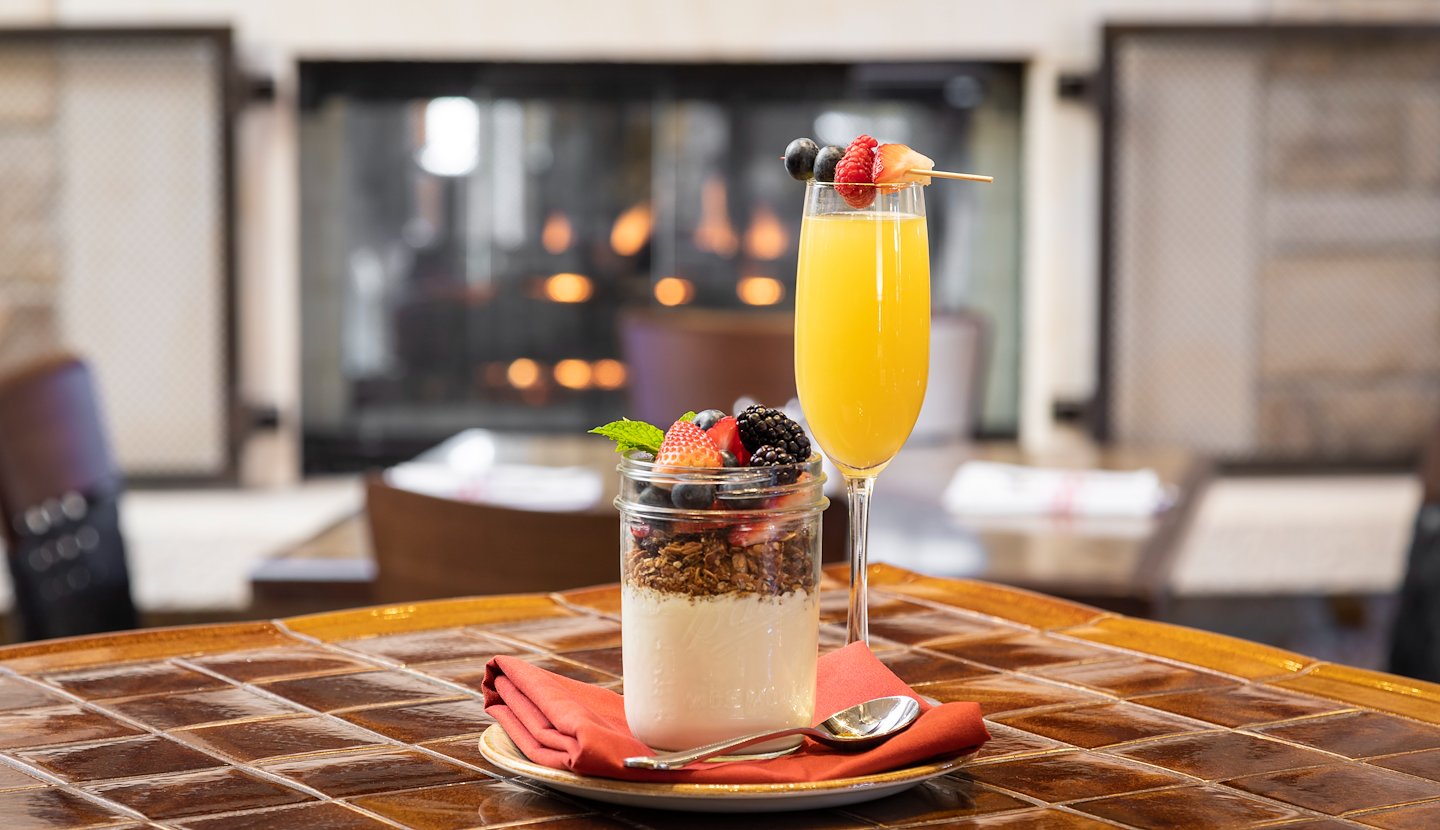 A table with a glass of orange juice and a bowl of fruit, Casa Munras Garden Hotel & Spa, Monterey, California