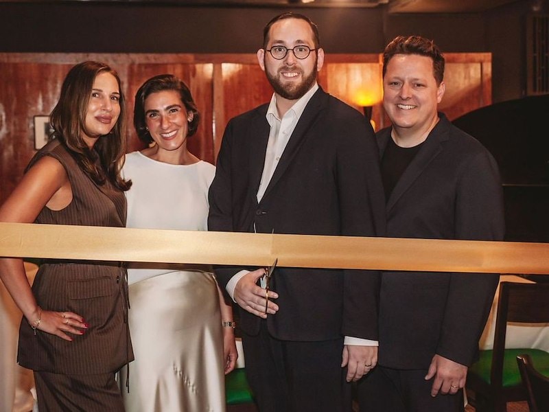 A group of people standing next to a ribbon