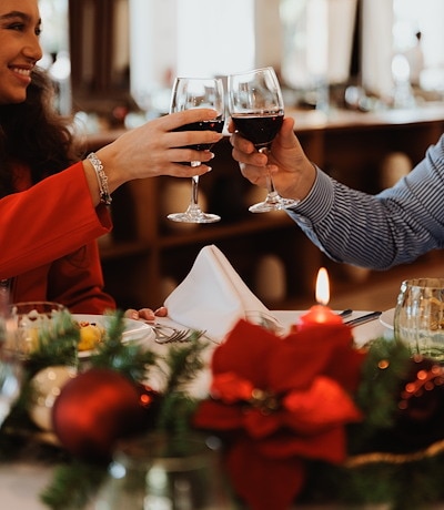Família a celebrar a Ceia de Natal à mesa, com decoração natalícia, no NAU São Rafael Suites, em Albufeira, Algarve.