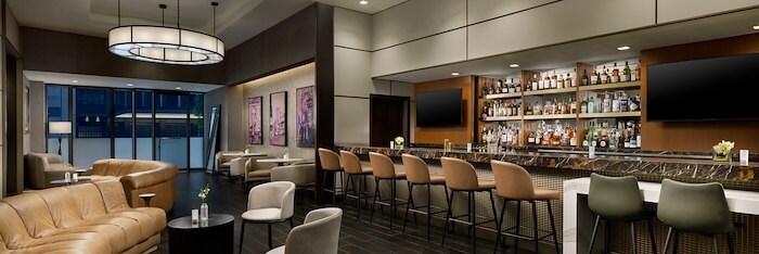 A Hotel Lobby With A Bar And Chairs at The Muse New York