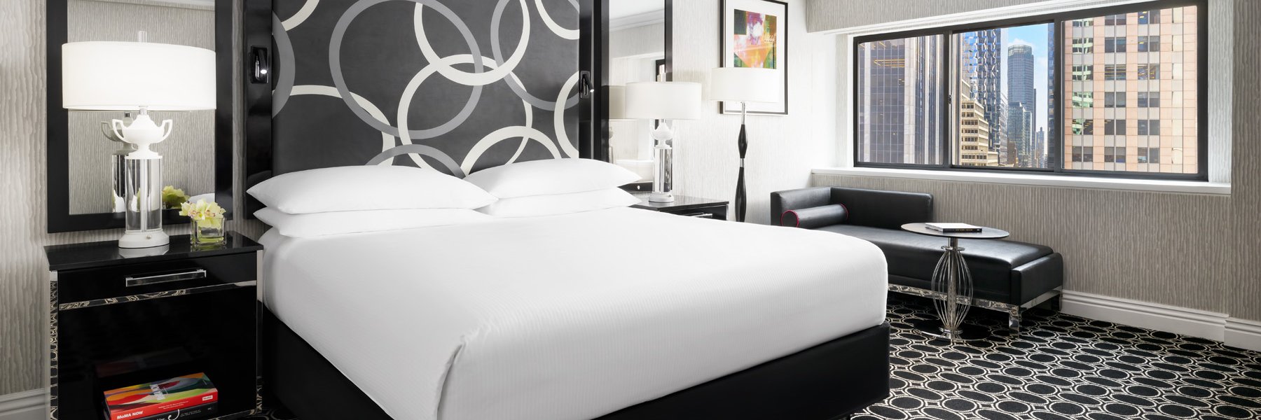 A Hotel Room With A Cozy Bed And Photo Pillow at The Muse New York