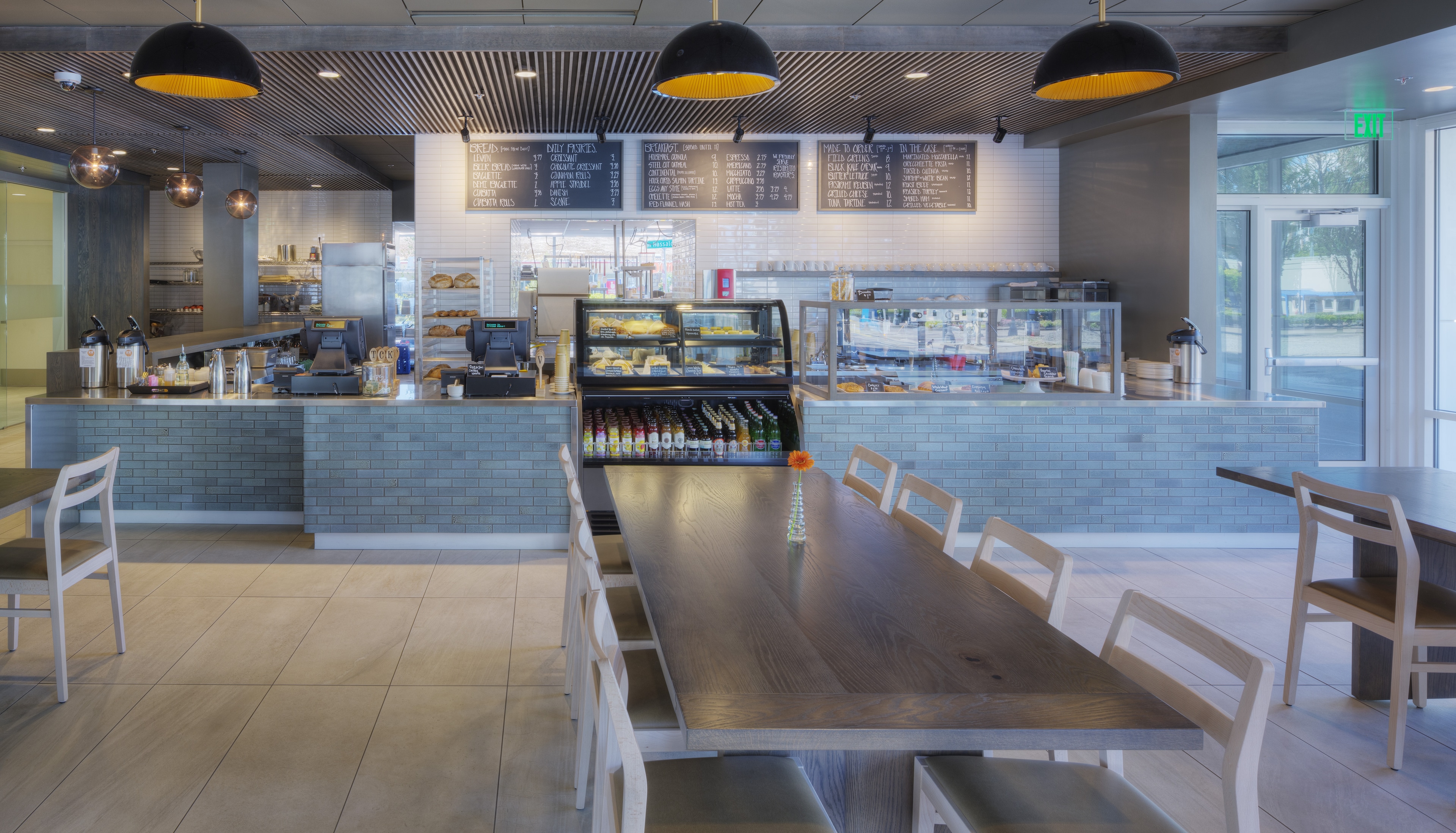 a brightly lit breakfast area with a menu board, food and beverage options