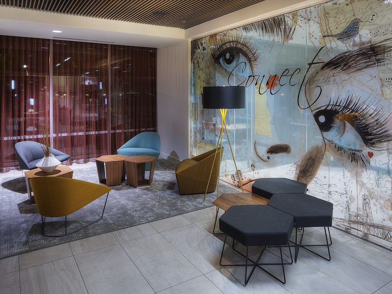 A lobby seating area with a large mural on the wall
