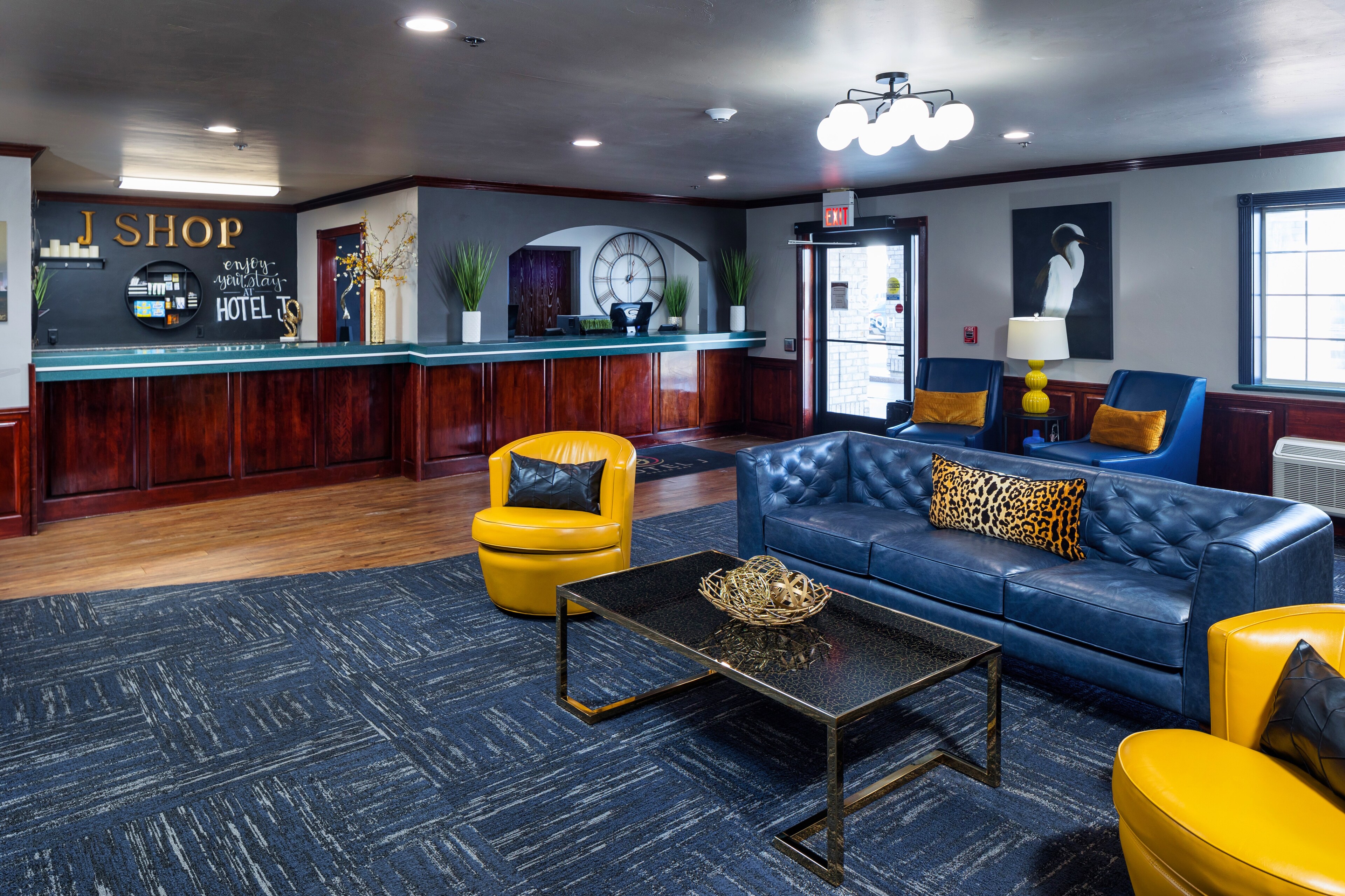 A lobby with a blue couch, yellow chairs, and a reception desk Hotel J, Green Bay, Wisconsin.