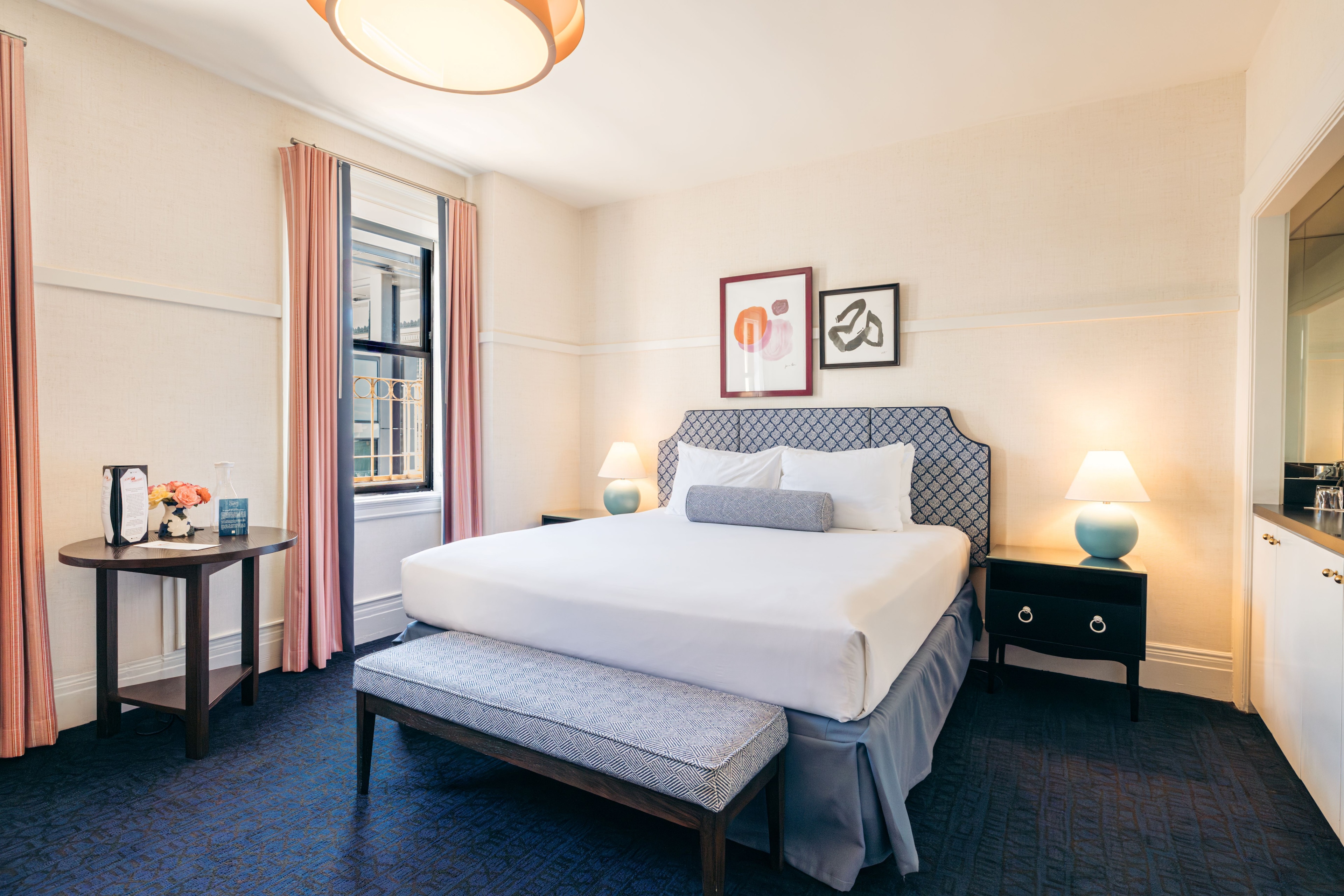 A hotel room with a large bed, nightstands, and a window