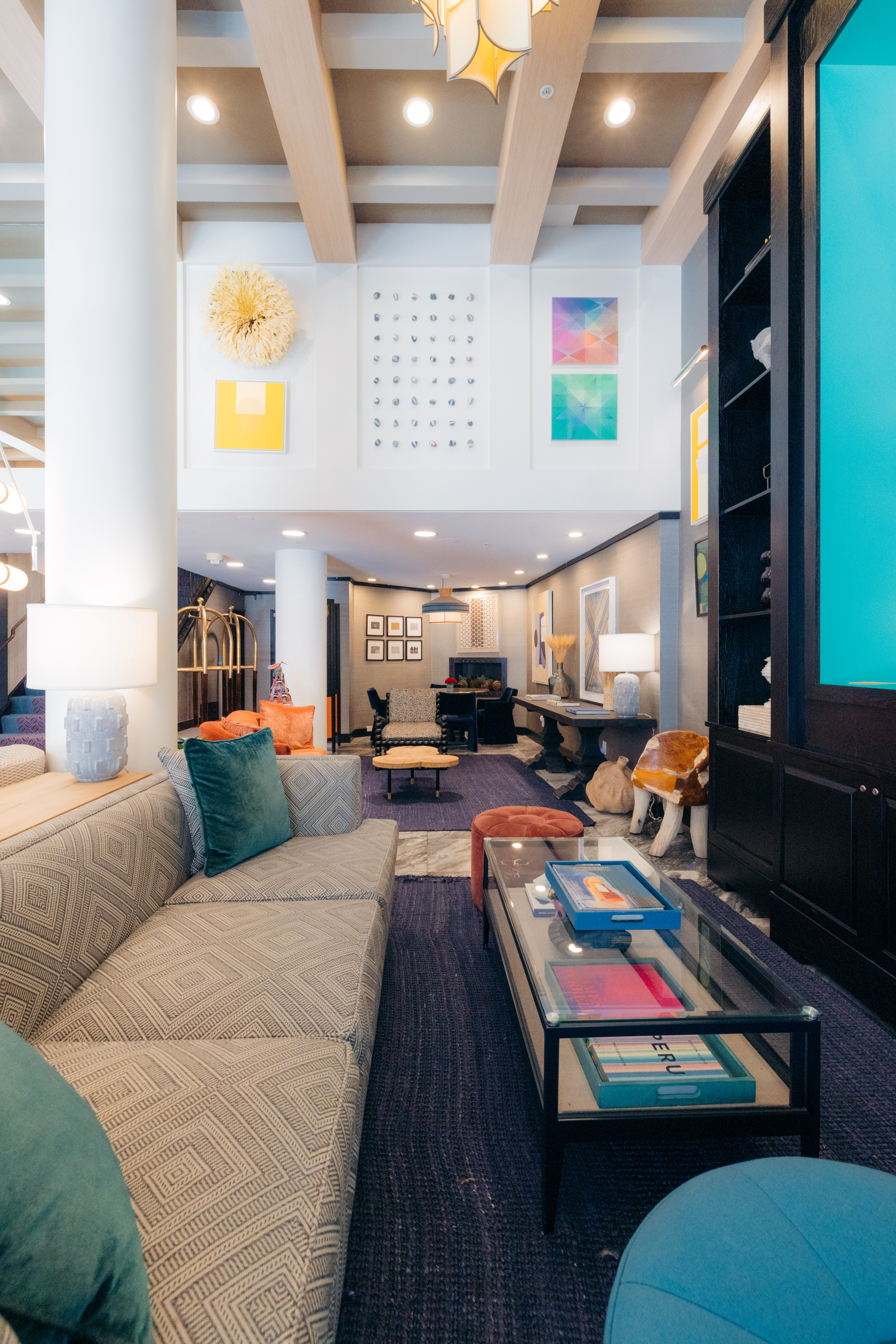 A wide view of a hotel lobby with a sofa, coffee table, and high ceiling