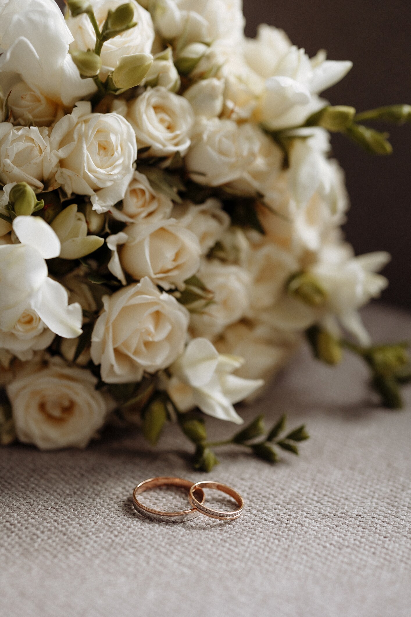 A bouquet of white flowers with wedding rings