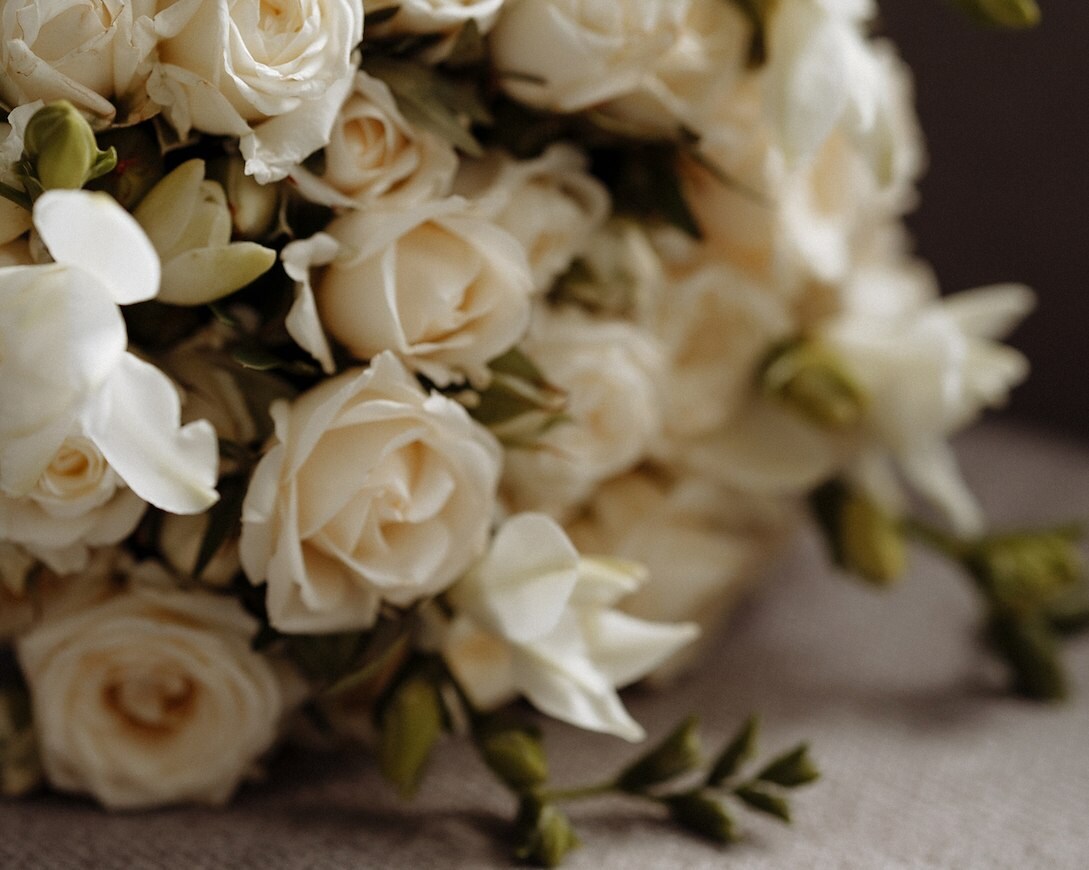 Wedding rings displayed beneath flowers
