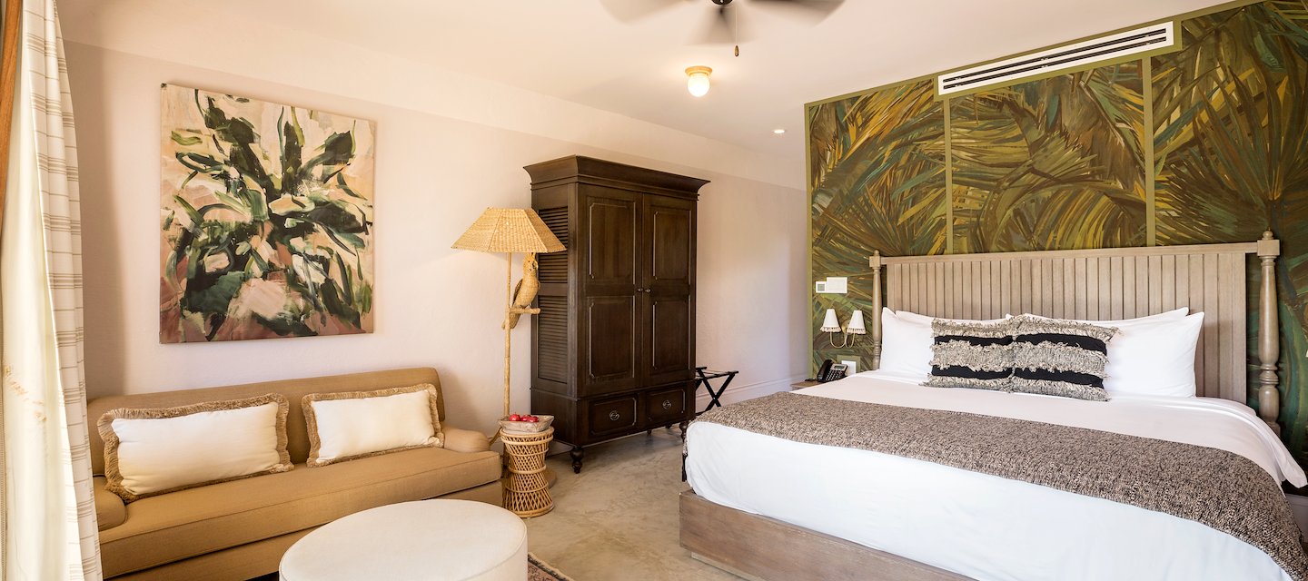 Deluxe Room king bedroom at Itz’ana Resort in Belize