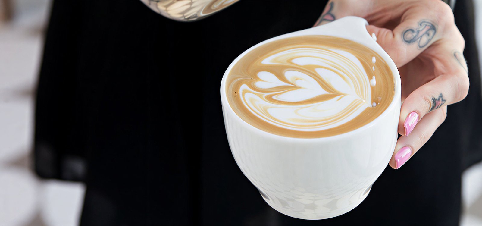 A barista with latte art cup at Jane Q in Hollywood, CA.