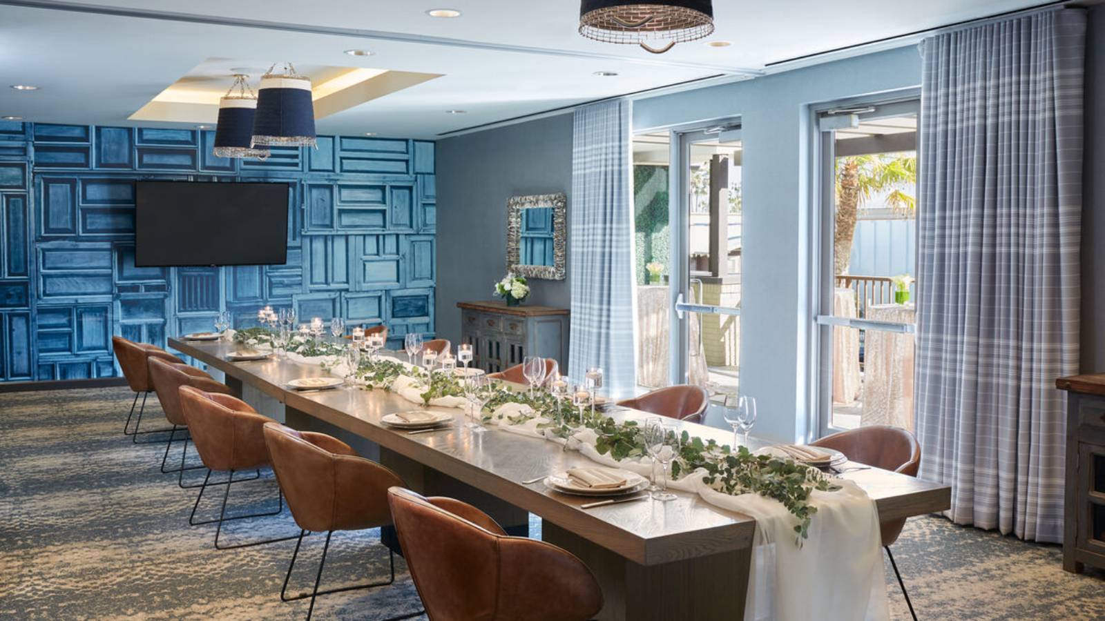 Elegant private dining room with greenery centerpiece at Pacific Hideaway, Huntington Beach, CA.