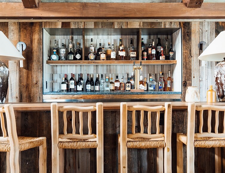 Bar at The Lodge, AWOL Stowe, with stools and shelves of bottles