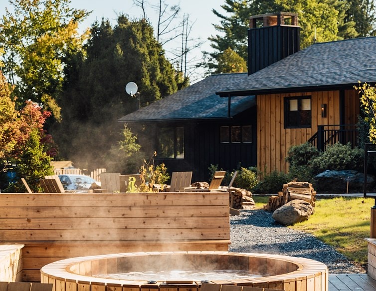 Steaming outdoor hot tub surrounded by Adirondack chairs at AWOL Stowe