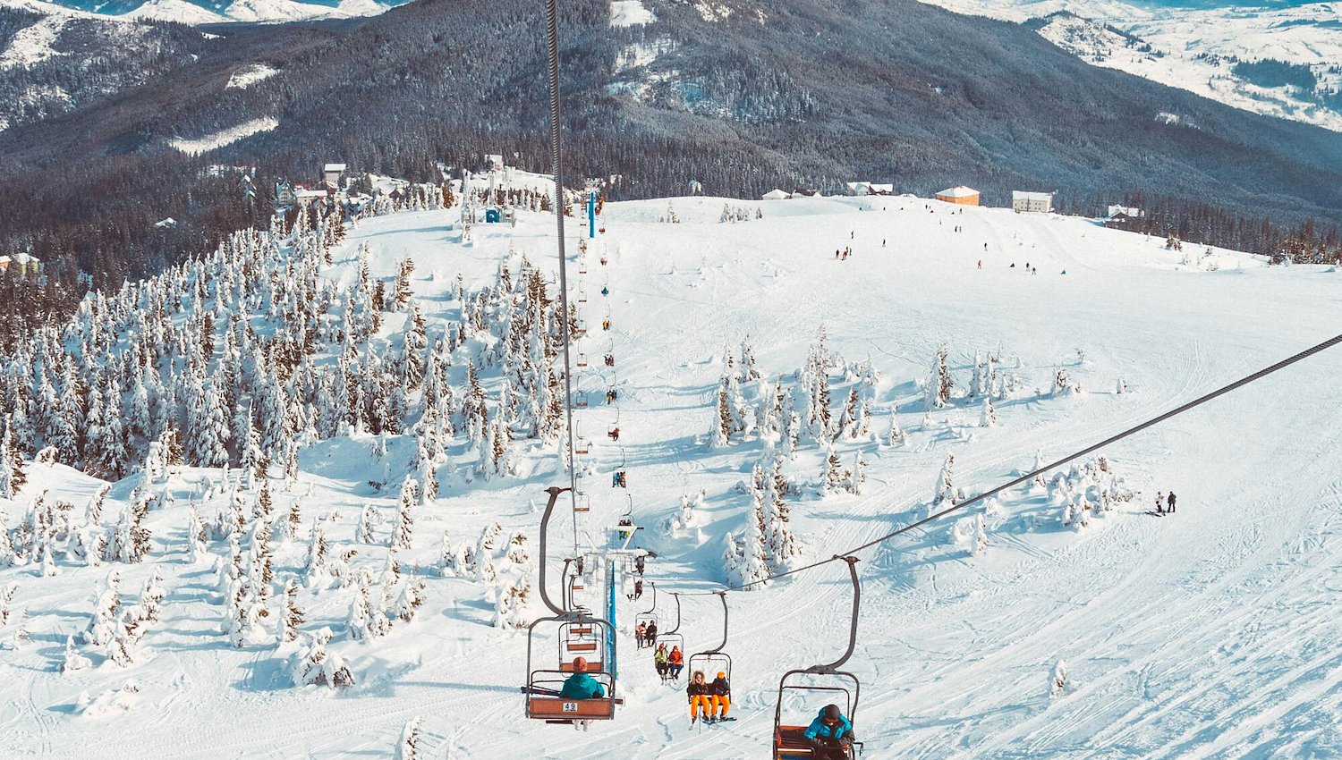 Skiiers on ski lift on snow covered mountains in Vermont
