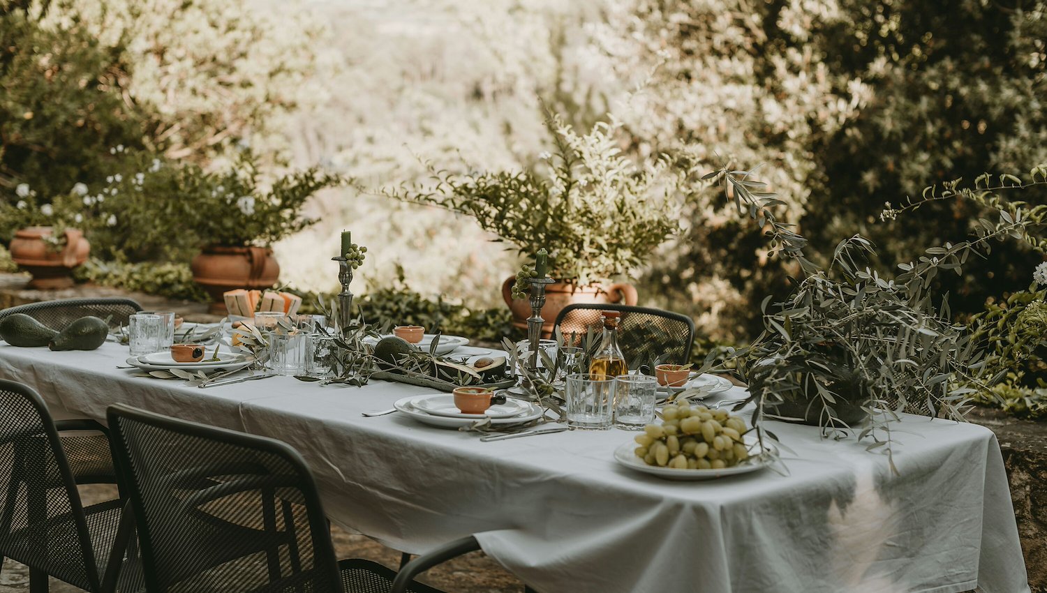 An inviting outdoor dining table set with white linens and natural decor at AWOL Stowe, VT