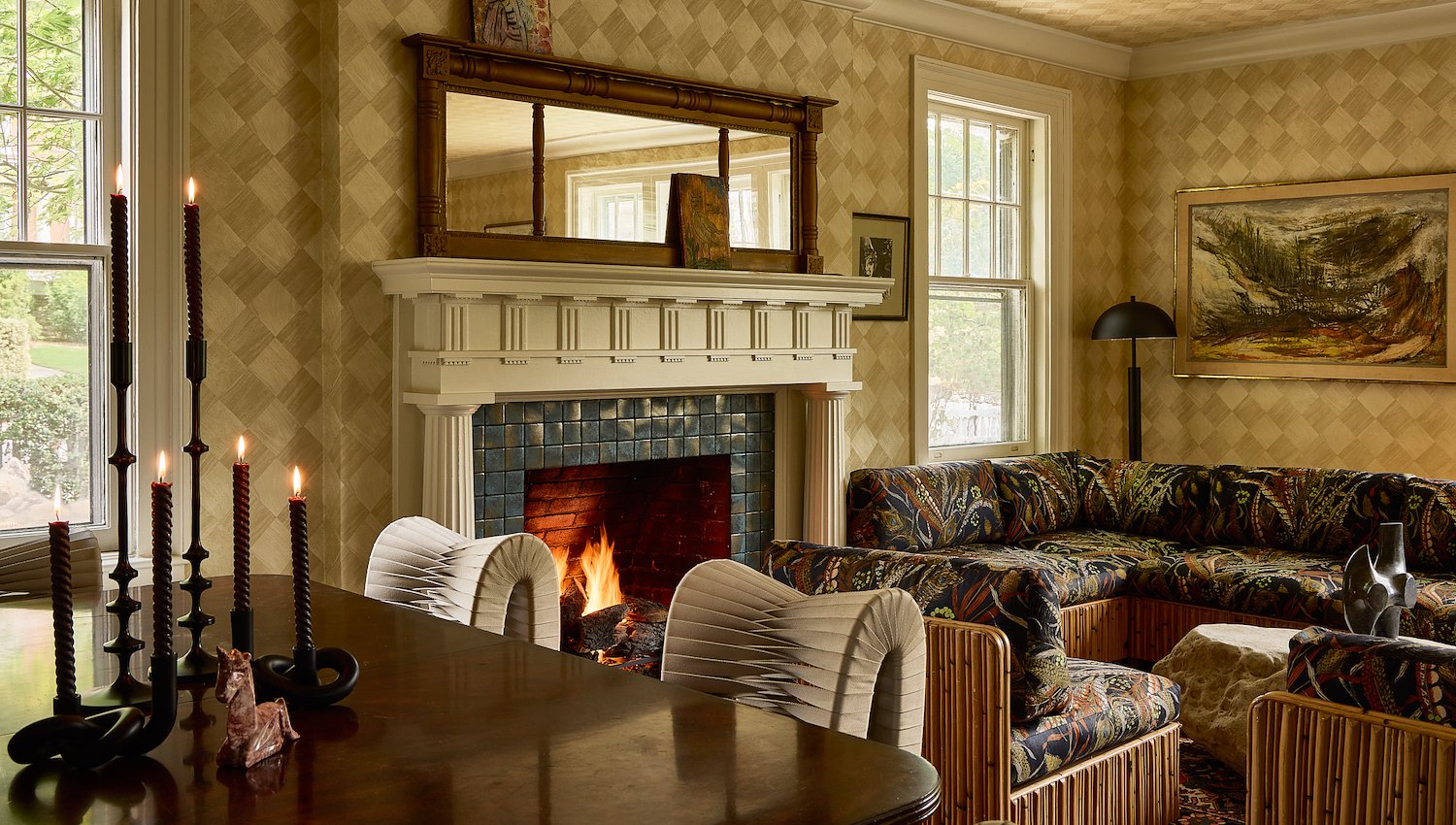 Cozy Blind Tiger lounge with a wood-burning fireplace, patterned seating and warm vintage-inspired decor.
