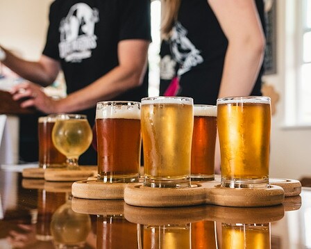  Wooden tasting platter with samples of assorted beer, cider, and mead. 