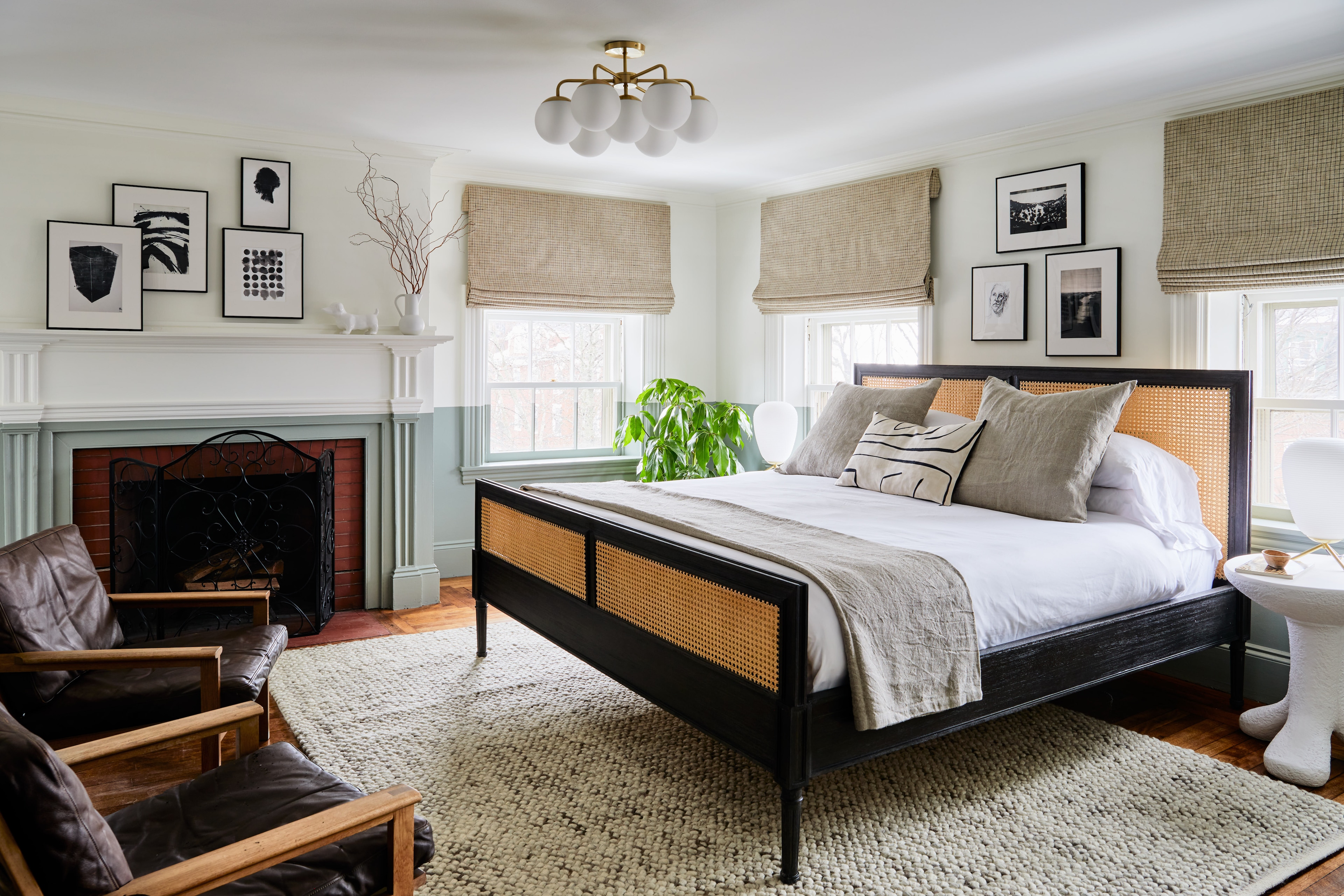 A wide view of a hotel room with a bed, fireplace, and window.