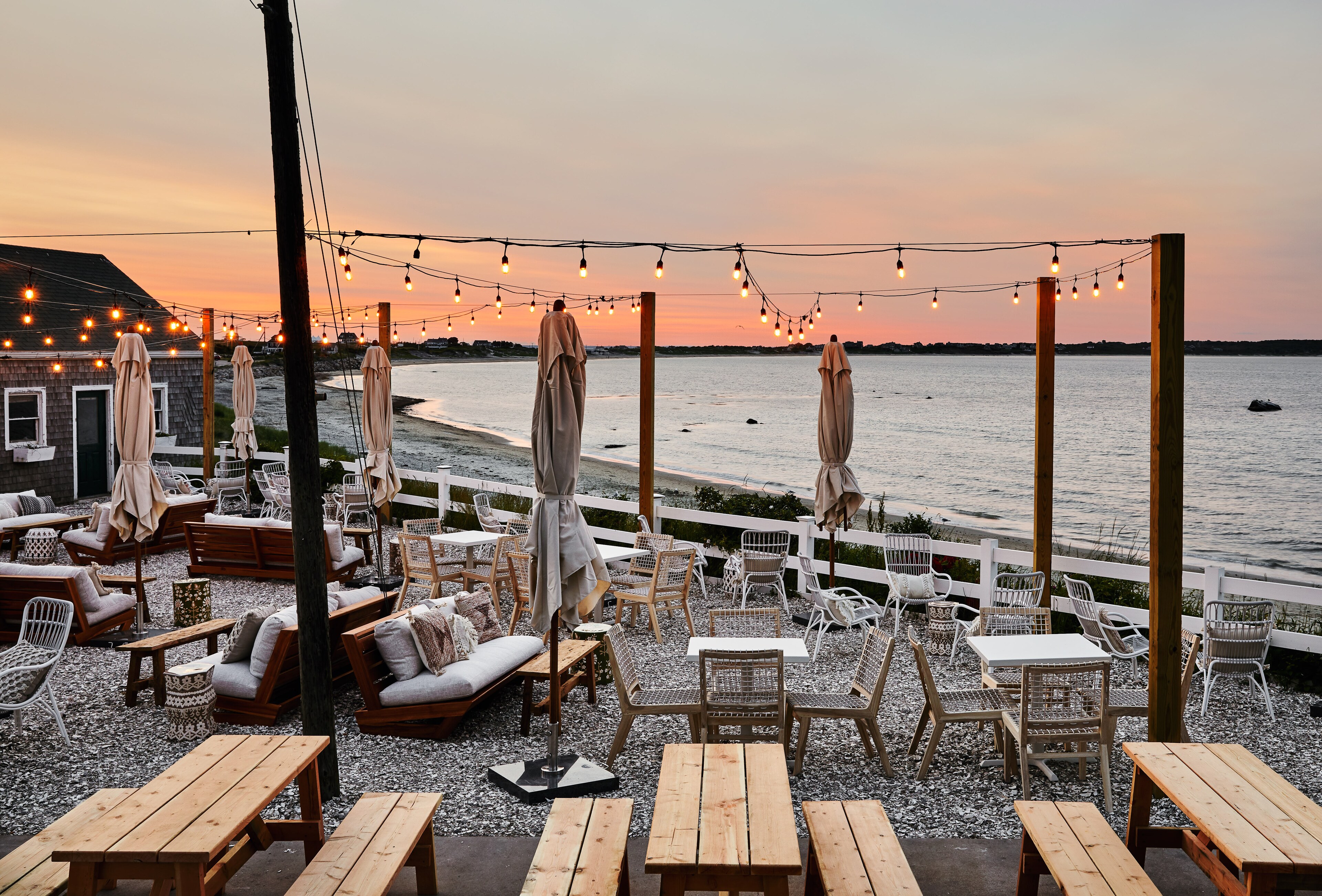Outdoor dining and lounge area at Block Island Gothic Inn with sunset ocean views
