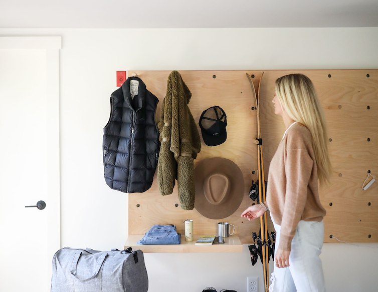 Guest preparing for a day outdoors with skis, boots, jackets and gear in a hotel room.