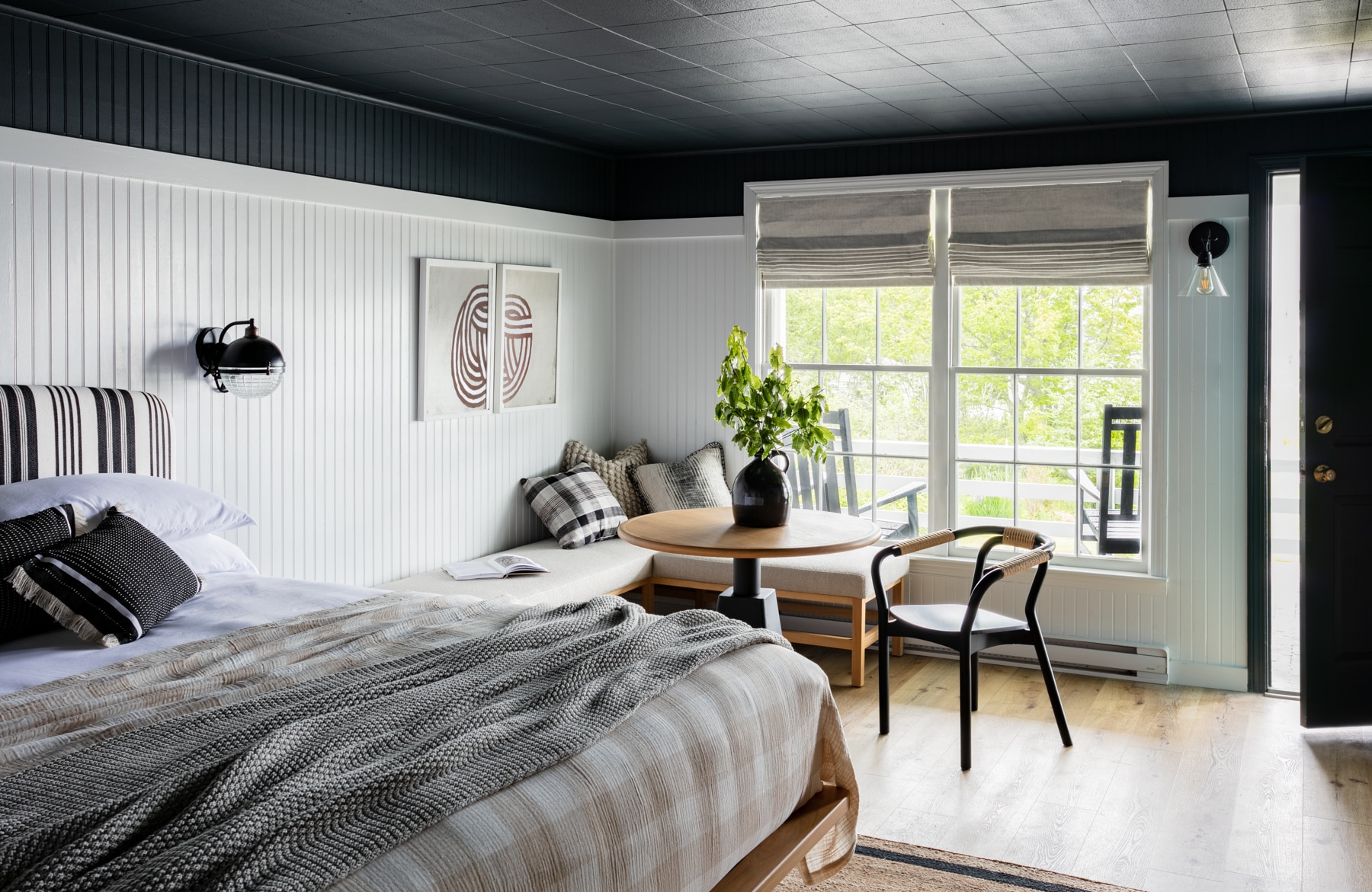A wide view of a hotel room with a bed, seating area, and window.