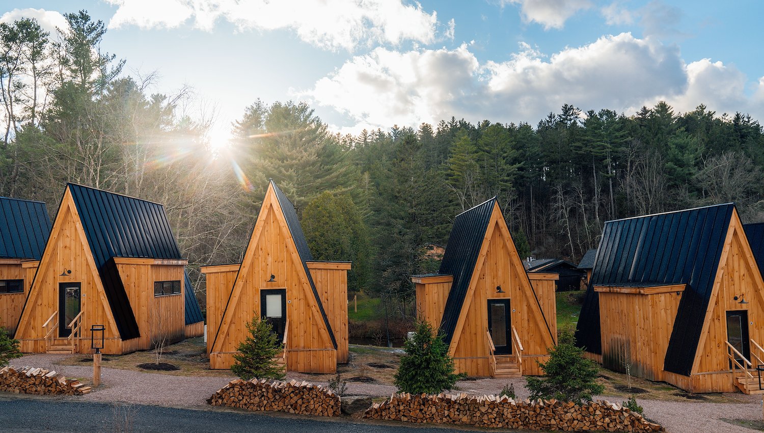 Wooden A-frame cabins surrounded by forest in Stowe Vermont
